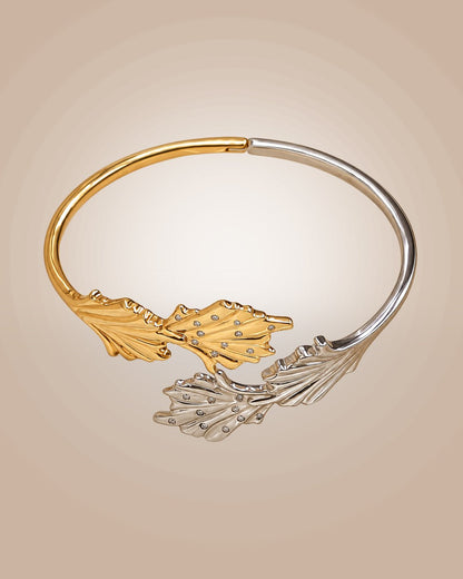 925 sterling silver bypass cuff bracelet with 22K gold vermeil and rhodium plating, featuring coral reef-inspired motifs with paved CZ accents and an anti-tarnish finish on a warm beige background.