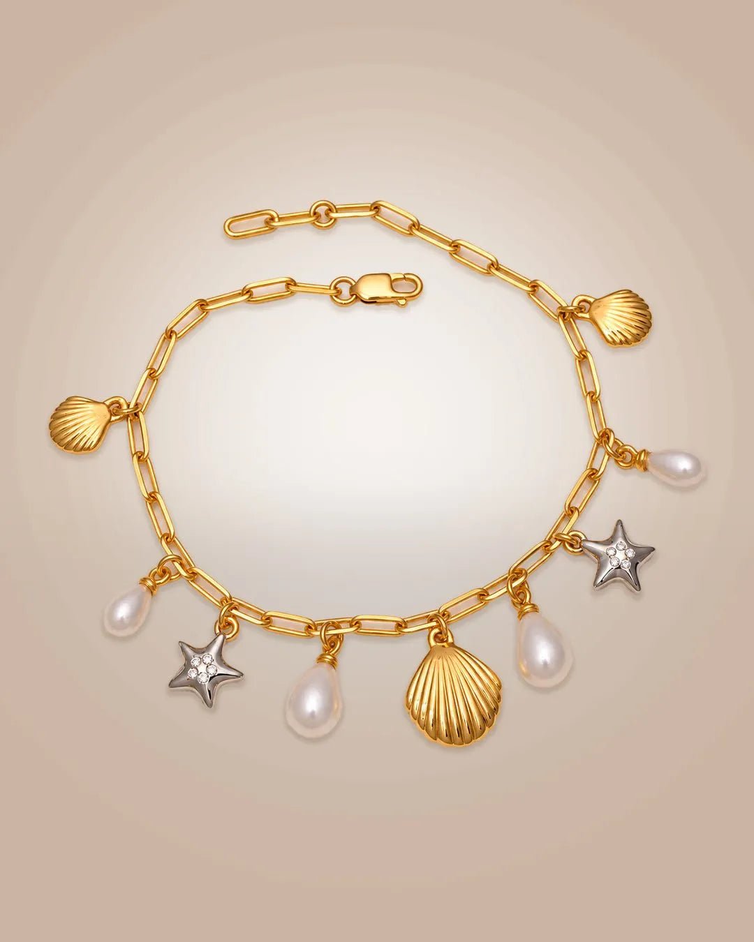 925 silver 22K gold vermeil & rhodium charm bracelet with shells, starfishes & pearls; anti-tarnish on beige background.