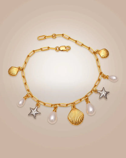 925 silver 22K gold vermeil & rhodium charm bracelet with shells, starfishes & pearls; anti-tarnish on beige background.